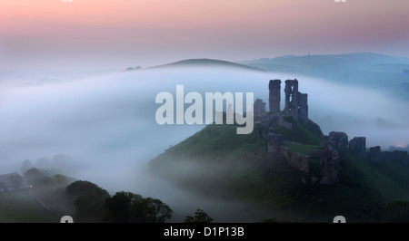 Le rovine di Corfe Castle nel Dorset fuori luogo della nebbia. Foto Stock