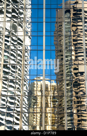 Le riflessioni nella facciata di vetro di un grattacielo adiacenti di una vicina torre di uffici Foto Stock