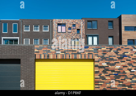 Vista posteriore di nuova costruzione di nuove e moderne case nei Paesi Bassi con un giallo porta di garage Foto Stock