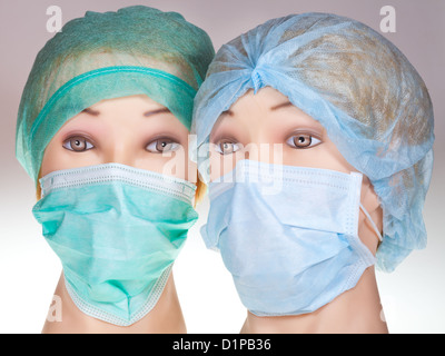 Due donne medico dummy indossando capi tessili cappuccio chirurgica e medica maschera protettiva Foto Stock