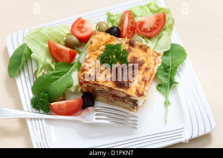 Un tradizionale moussaka greca , realizzati con strati di patate, melanzana, carne e salsa di pomodoro condito con besciamella Foto Stock