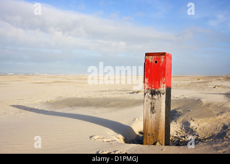 La spiaggia rossa pole con lunga ombra sulla grande spiaggia Foto Stock