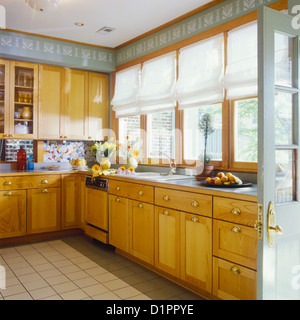 Cucine contemporanee globale legno armadi di tinto brass tira verde chiaro con pareti bianche geometrica stampata arti e Foto Stock