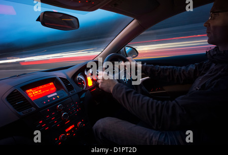 La guida veloce verso il basso di un'autostrada di notte dall'interno dell'auto. Foto Stock