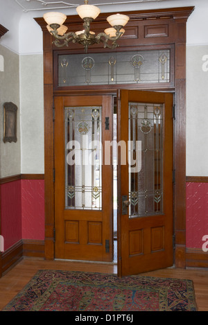 Ingresso arti e mestieri entrata anteriore porte Francesi con benzina contenente piombo e vetro macchiato sullo specchio di poppa architettonici dettagliati dado del rivestimento Foto Stock