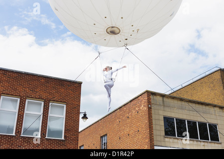 Un trapezista è sospeso da un grande palloncino elio durante una performance Heliosphere. St Albans, Regno Unito 2012 Foto Stock