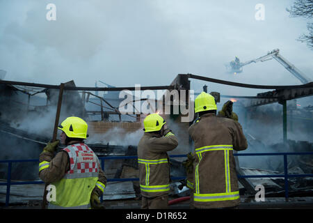 Negozi di triangolo, Laindon, Basildon, Essex. Quattro negozi sono stati rasi al suolo dopo un incendio appiccato in un cinese take-away in parata noto come il Triangolo negozi. Si ritiene che l incendio è scoppiato in un aeratore e diffondersi a tutta la sfilata di distruggere altre tre imprese. Gli altri negozi erano un parrucchiere, un ufficio postale e un negozio di generi alimentari. Non è noto per aver causato danni. Fire ufficiali il rilevamento della scena. Foto Stock