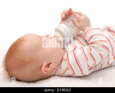 Baby girl bere latte dalla bottiglia Foto Stock