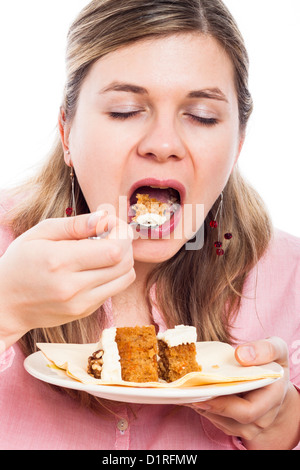 Close up della giovane donna di mangiare la torta di carote. Foto Stock