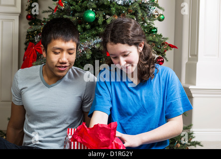 Fratello e Sorella cercando in borsa regalo il giorno di Natale Foto Stock