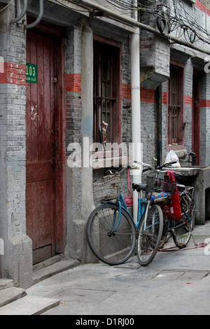 Bike puntellato contro una casa di mattoni a Shanghai in Cina Foto Stock