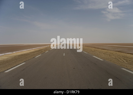 La causeway e la strada che attraversa il Chott El Jerid Salt Lake da Tozeur a Tebili nel deserto del Sahara in Tunisia Foto Stock