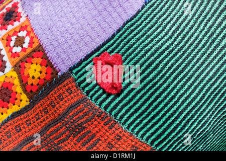 Frammento di maglia fatti a mano da un filato sintetico di una femmina di striped macchie maglione sfondo texture. Arte selettiva di messa a fuoco Foto Stock