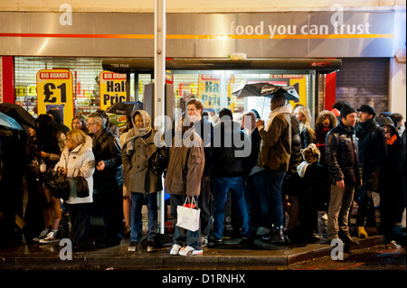 Coda di persone sotto la pioggia per gli autobus a Clapham Common nelle prime ore. Giorno di nuovi anni, Londra, 01 01 2013 Foto Stock