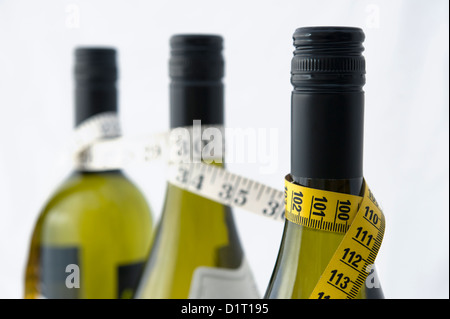 Una misura di nastro avvolti intorno a bottiglie di vino. Potrebbe essere usato per illustrare il concetto di calorie in bevanda alcolica e dieta Foto Stock