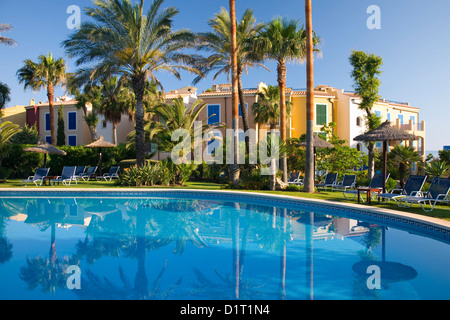 Colonia de Sant Pere, Maiorca, isole Baleari, Spagna. Vista sulla piscina al complesso di appartamenti di lusso adagiato tra palme. Foto Stock