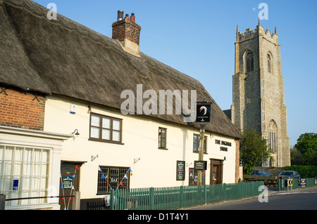 Il Cigno pub e ristorante a Ingham NORFOLK REGNO UNITO con la Chiesa della Santissima Trinità Foto Stock