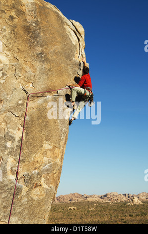 Un uomo portare arrampicata su roccia a Joshua Tree National Park Foto Stock