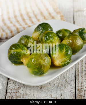 Arrosto di cavolini di Bruxelles in un piatto bianco Foto Stock