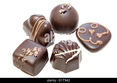 Cioccolato fondente assortimento con tartufi cuore volute dadi isolati su sfondo bianco Foto Stock