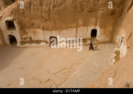 Berber casa troglodita e vecchia donna vicino a Matmata nel deserto del Sahara in Tunisia Foto Stock