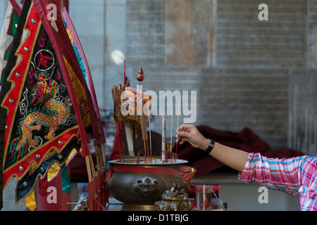 Un Buddista devoto luoghi offerte di incenso presso un santuario in Chinese Thean Hou tempio di Penang, Malaysia Foto Stock