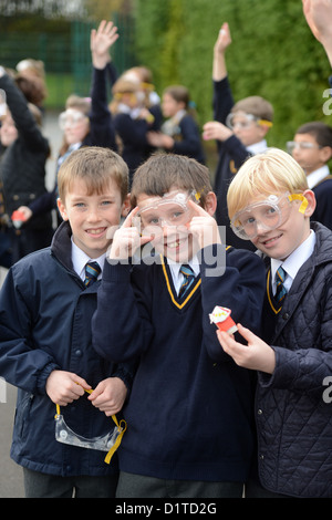 I ragazzi della scuola con gli occhiali di sicurezza durante un esterno di lancio del razzo lezione di scienze presso la Madonna e San Werburgh cattoliche del Sch primario Foto Stock
