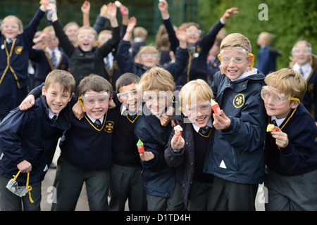 I ragazzi della scuola con gli occhiali di sicurezza durante un esterno di lancio del razzo lezione di scienze presso la Madonna e San Werburgh cattoliche del Sch primario Foto Stock
