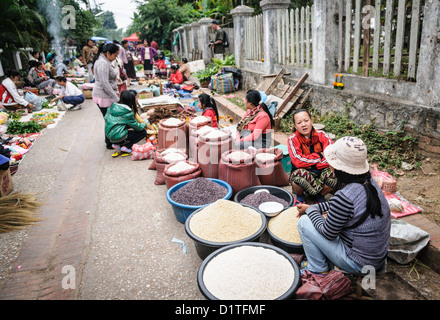 LUANG PRABANG, Laos - il vivace mercato mattutino di Luang Prabang, Laos, presenta una vibrante gamma di prodotti freschi, prelibatezze locali e prodotti tradizionali. Venditori e acquirenti si mescolano tra una variegata varietà di frutta, verdura, erbe aromatiche e altri piatti tipici della cucina laotiana, offrendo uno sguardo alla vita quotidiana e alla cultura gastronomica locale. Foto Stock