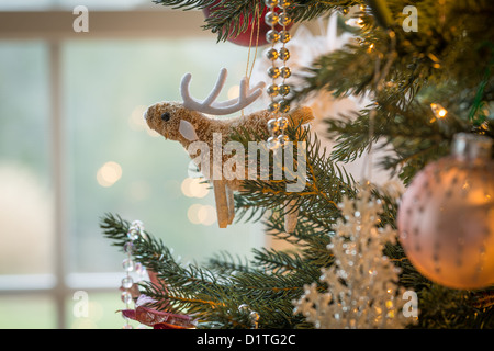 Macro shot di graziosi raindeer con corna sulla piscina albero di natale con decorazioni Foto Stock