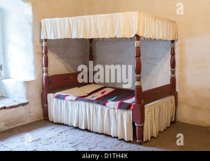 Tradizionale letto a baldacchino con coperta in vecchio pavimento in pietra camera da letto Foto Stock