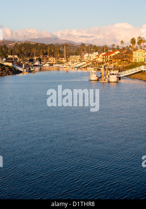 Tramonto su sviluppo residenziale da acqua a Ventura California con case moderne e yacht barche Foto Stock