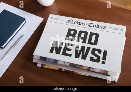 Concetto di giornale con hot topic " Bad news' giacente sulla scrivania in ufficio. Foto Stock