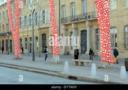 Pedoni passeggiando davanti a un Hotel Particulier o Bourgeois Town House e avvolto piano albero decorato in rosso e bianco Polka Dot Paper da artista giapponese Yayoi Kusama Cours Mirabeau Aix-en-Provence per l'inaugurazione di Marsiglia-Provenza 2013 capitale europea della cultura. Provenza Francia Foto Stock