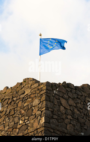 Bandiera dell'Unione europea a volare su un vecchio edificio in pietra vicino a Bushmills in County Antrim Irlanda del Nord Regno Unito Regno Unito Foto Stock