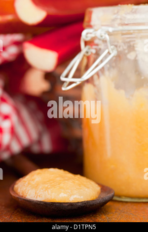 Fatta in Casa marmellata di rabarbaro nel vasetto di vetro e il cucchiaio di legno Foto Stock