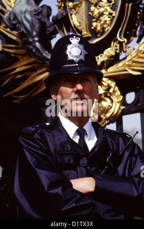 Un poliziotto britannico indossa custode tipico casco o casco centurion al cancello di Buckingham Palace Londra REGNO UNITO Inghilterra Foto Stock