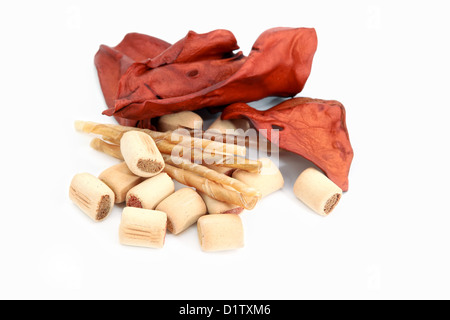 Cane snack, masticare bastoncini e carni bovine orecchie su sfondo bianco Foto Stock