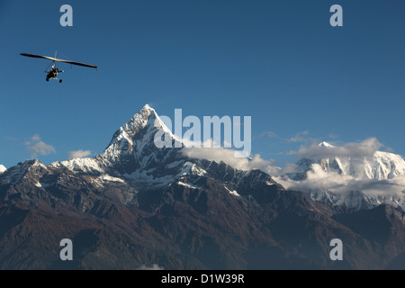 Volo Ultraleggero vicino al Machapuchare (aka coda di pesce della montagna) nel Santuario di Annapurna, Nepal Foto Stock