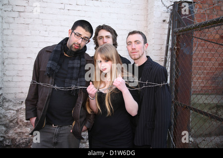 Un gruppo di amici di adolescenti che hanno formato un heavy metal rock band, ingannare circa durante un servizio fotografico con falso filo spinato Foto Stock