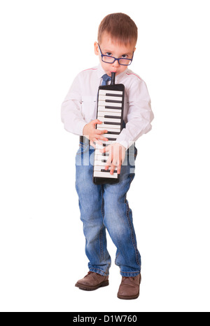 Ragazzo di età prescolare in bicchieri, jeans e maglietta bianca giocando melodica, isolato su sfondo bianco Foto Stock