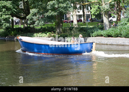 Barca che scivola giù il fiume di Amsterdam in un giorno caldo e soleggiato Foto Stock