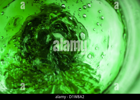 Vortice verde all'interno della bottiglia liquido di versamento Foto Stock