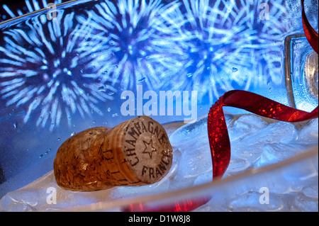 Tappo dello Champagne e il ghiaccio in wine cooler con party red streamer e fuochi d'artificio celebrazioni dietro Foto Stock