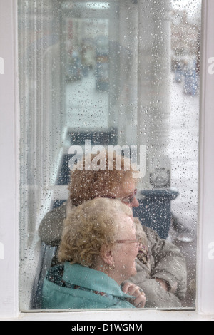 Due allegro old ladies si ripara dalla pioggia a Weymouth Dorset, England, Regno Unito Foto Stock