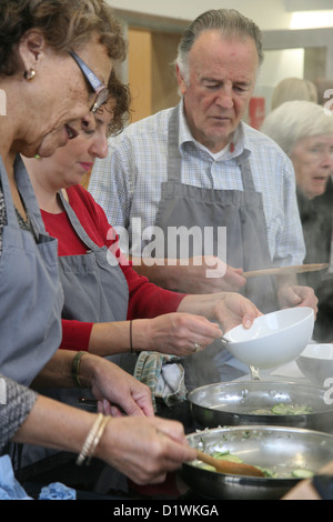 I pensionati di apprendimento delle competenze di cucina a scuola di cucina Foto Stock