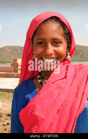 Ritratto di una giovane e bella ragazza di Rajasthani indossando il tradizionale sari colorati accanto all uomo Sagar lago a Jaipur, India. Foto Stock