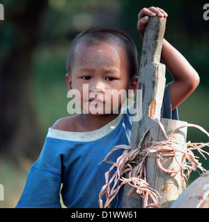 Ritratto di un giovane ragazzo che viaggiano su un carrello di giovenco. sulla strada tra Rangoon e Bago in Birmania, Myanmar, sud-est asiatico. Foto Stock