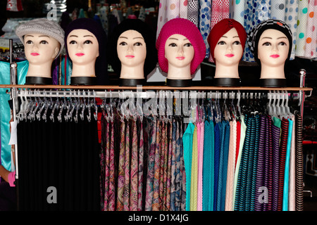 Righe di seta colorata in negozi lungo la Main Bazaar, Kuching, Sarawak Foto Stock