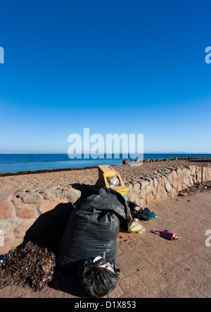 Traboccante abbandonato i bidoni e sacchi della spazzatura sinistra accanto ad una spiaggia tropicale Foto Stock